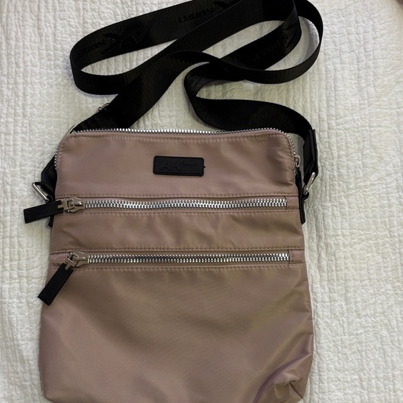 Anne Klein Sport Handbags - Anne Klein Sport Lilac Nylon Crossbody Bag with Black Adjustable Strap.